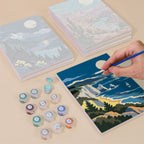 Painting one of the Moonlit Wilderness designs next to a stack of mini canvases