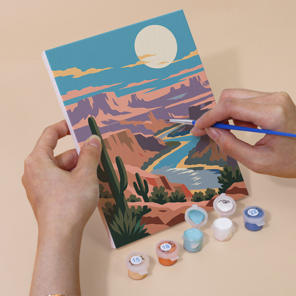 Hand holding a Moonlit Wilderness mini canvas while painting the details