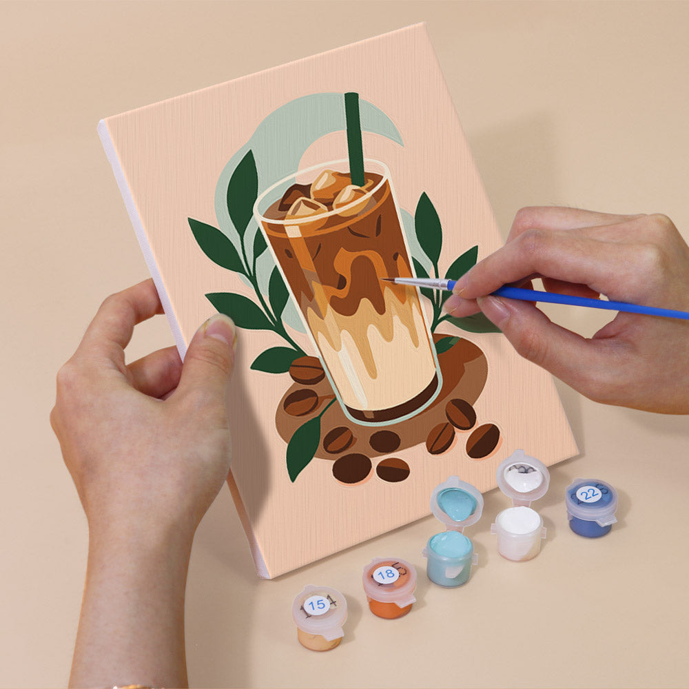 Hand holding a Morning Treats mini canvas while painting the details