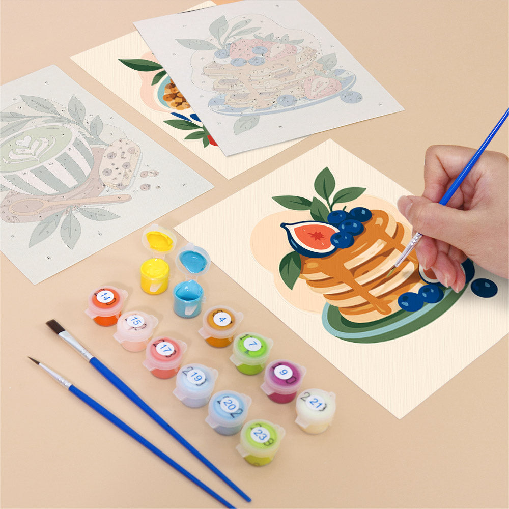 Filling in a Morning Treats mini canvas with numbered acrylic paints and a fine brush