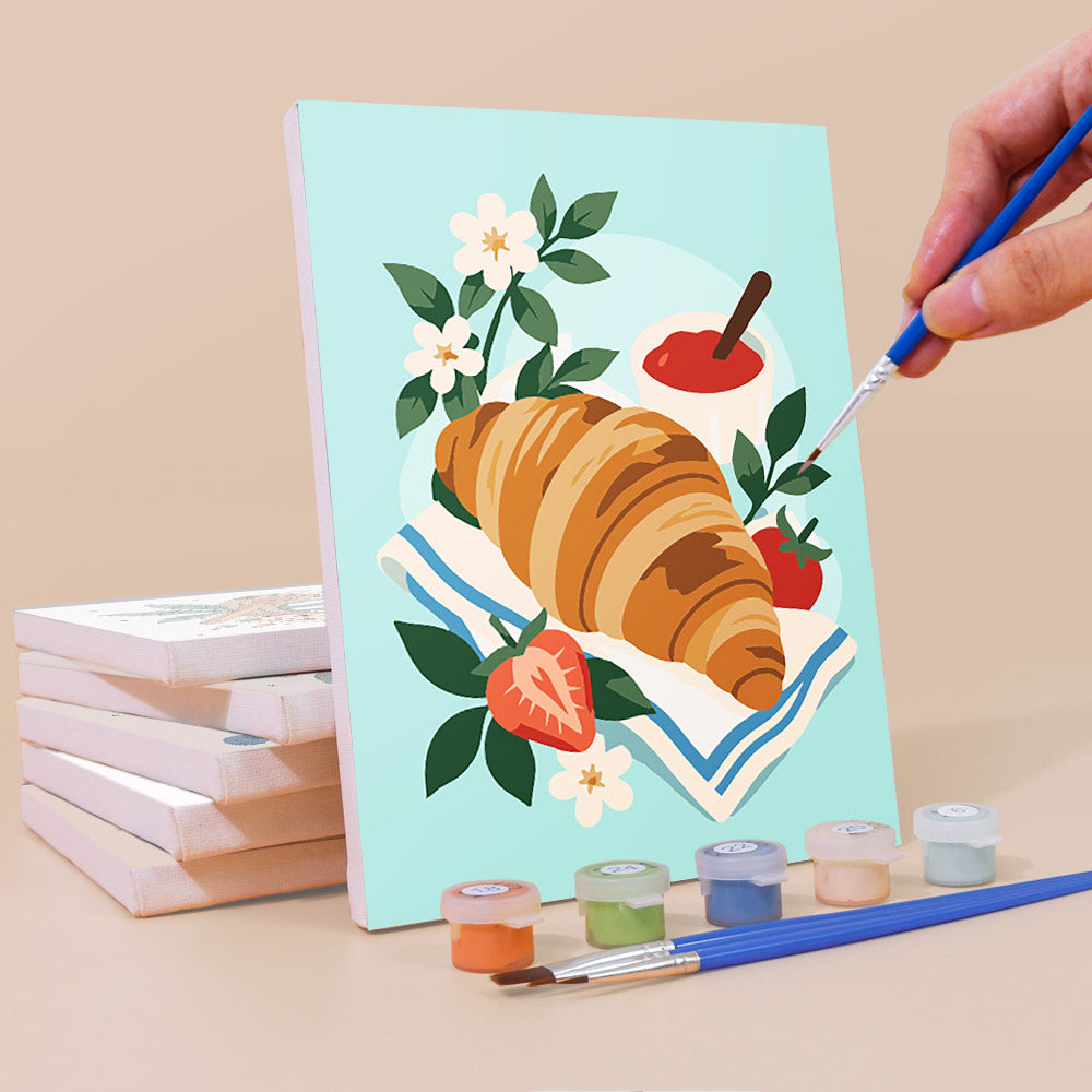 Painting a Morning Treats mini canvas propped up beside numbered acrylic paints