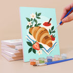 Painting a Morning Treats mini canvas propped up beside numbered acrylic paints