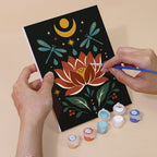 Hand holding a Mystic Folk mini canvas while painting the details