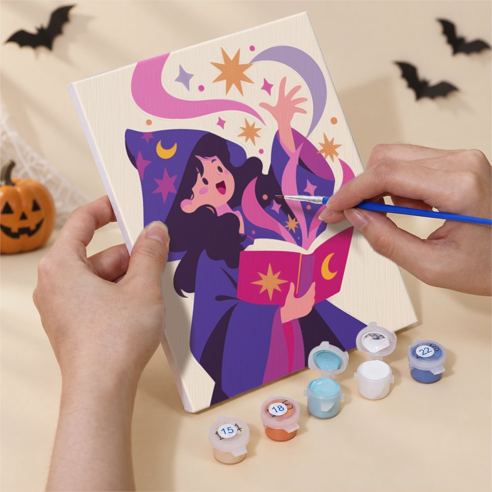 Hand holding a Mystic Moon Witches mini canvas while painting the details