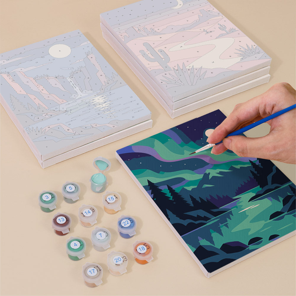 Painting one of the Night Sky Journeys designs next to a stack of mini canvases