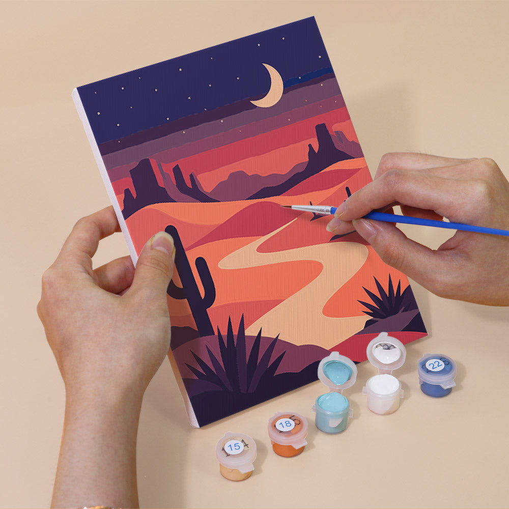 Hand holding a Night Sky Journeys mini canvas while painting the details