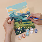 Hand holding a Northern Wilds mini canvas while painting the details