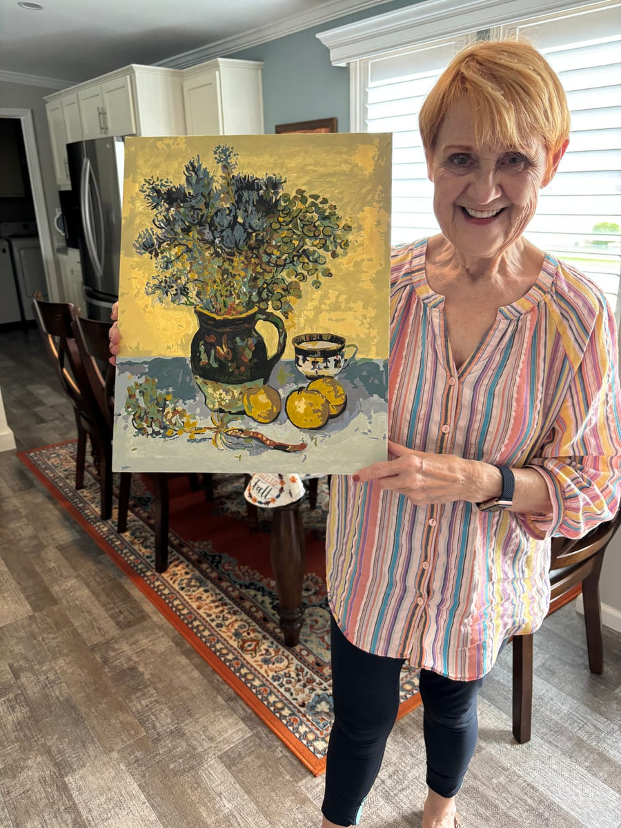 Happy customer holding her finished still life paint by numbers painting