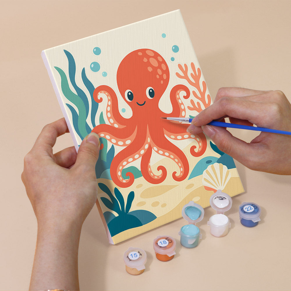 Hand holding an Ocean Friends mini canvas while painting the details
