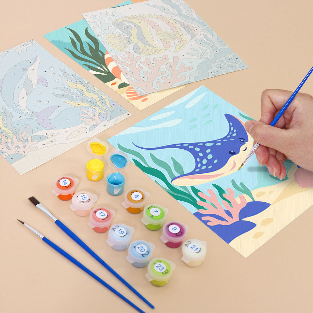Filling in an Ocean Friends mini canvas with numbered acrylic paints and a fine brush