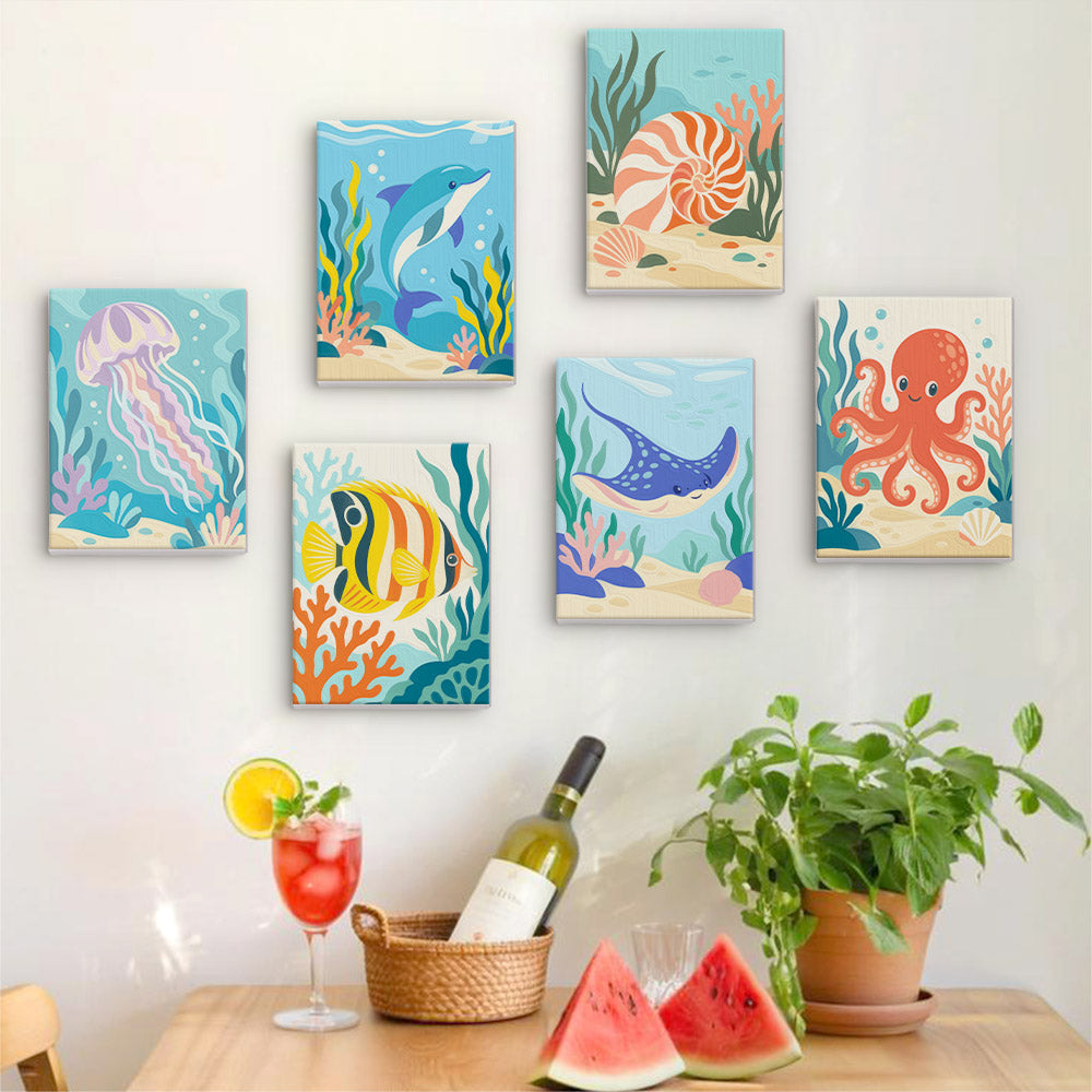 Six finished Ocean Friends mini paintings hung on a wall above a table