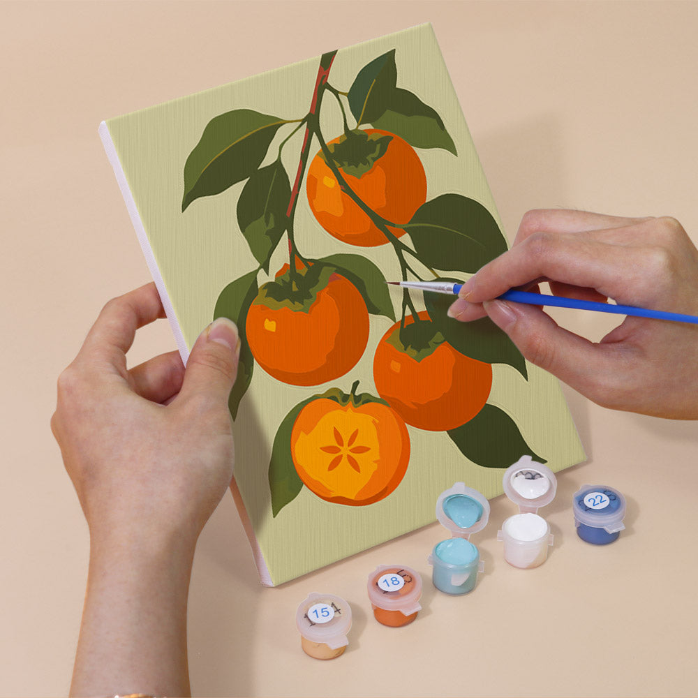 Hand holding an Orchard Harvest mini canvas while painting the details
