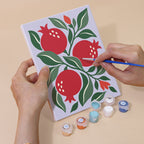 Hand holding an Orchard Prints mini canvas while painting the details