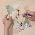 Hand holding a Painterly Blooms mini canvas while painting the details