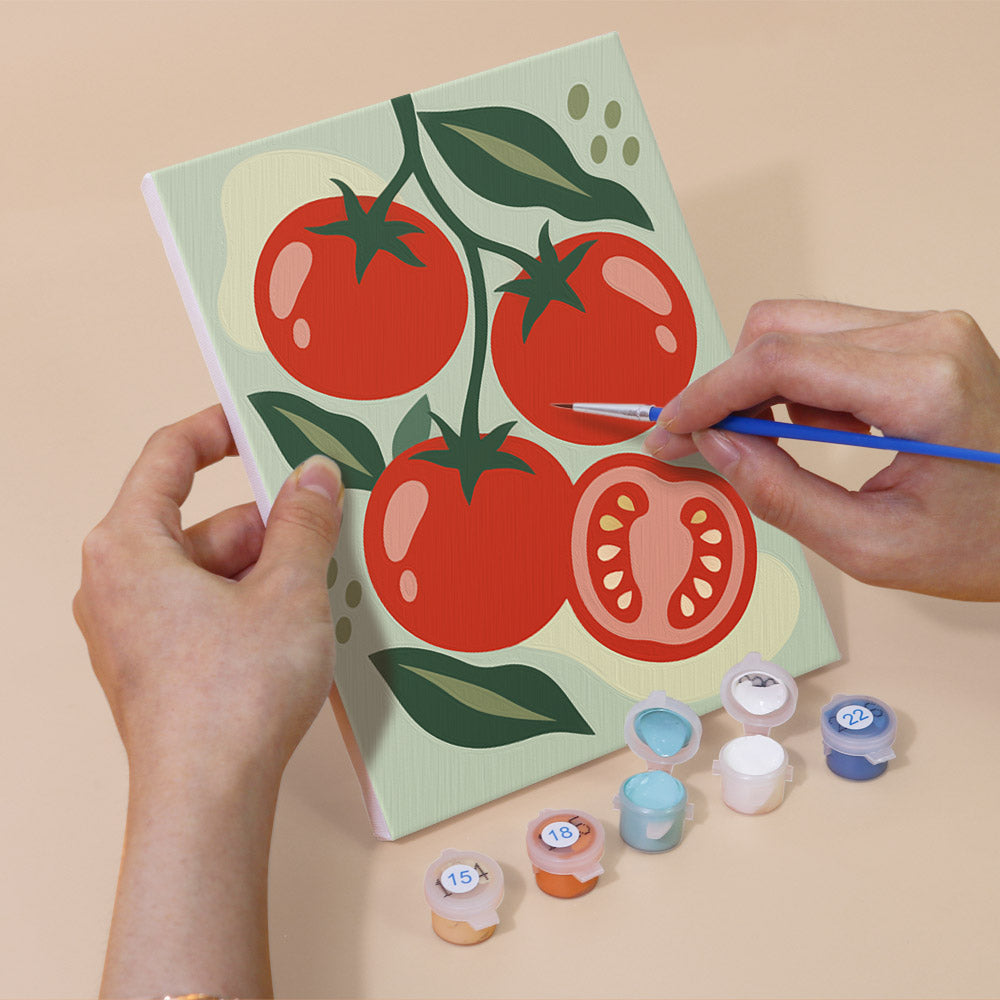 Hand holding a Pantry Harvest mini canvas while painting the details