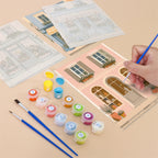 Filling in a Pastel Storefronts mini canvas with numbered acrylic paints and a fine brush