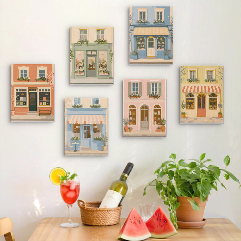 Six finished Pastel Storefronts mini paintings hung on a wall above a table