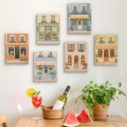 Six finished Pastel Storefronts mini paintings hung on a wall above a table