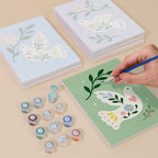 Painting one of the Peace Doves designs next to a stack of mini canvases