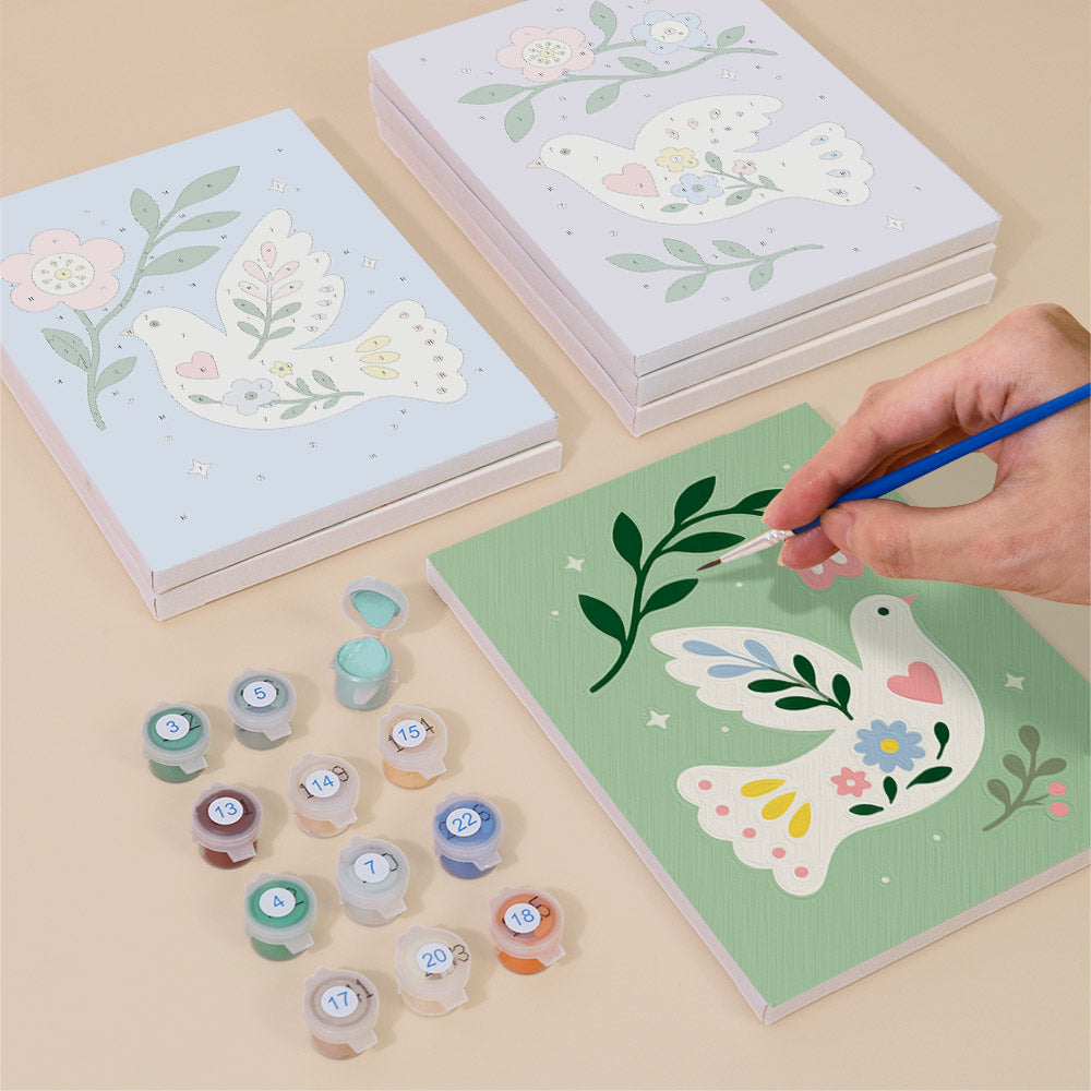 Painting one of the Peace Doves designs next to a stack of mini canvases