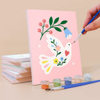 Painting a Peace Doves mini canvas propped up beside numbered acrylic paints