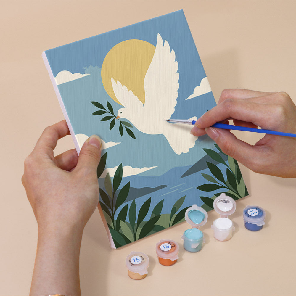 Hand holding a Peaceful Faith mini canvas while painting the details