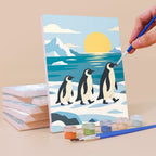 Painting a Penguin Shores mini canvas propped up beside numbered acrylic paints