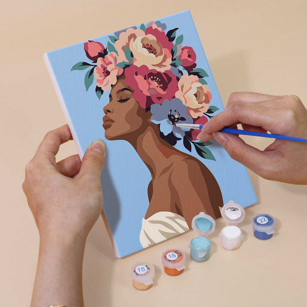Hand holding a Peony Portraits mini canvas while painting the details