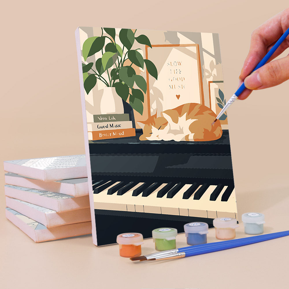 Painting a Piano Moments mini canvas propped up beside numbered acrylic paints