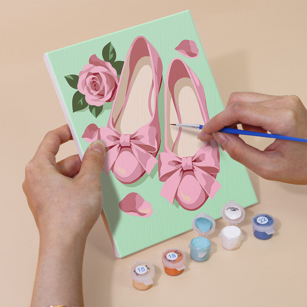 Hand holding a Pink Glam mini canvas while painting the details