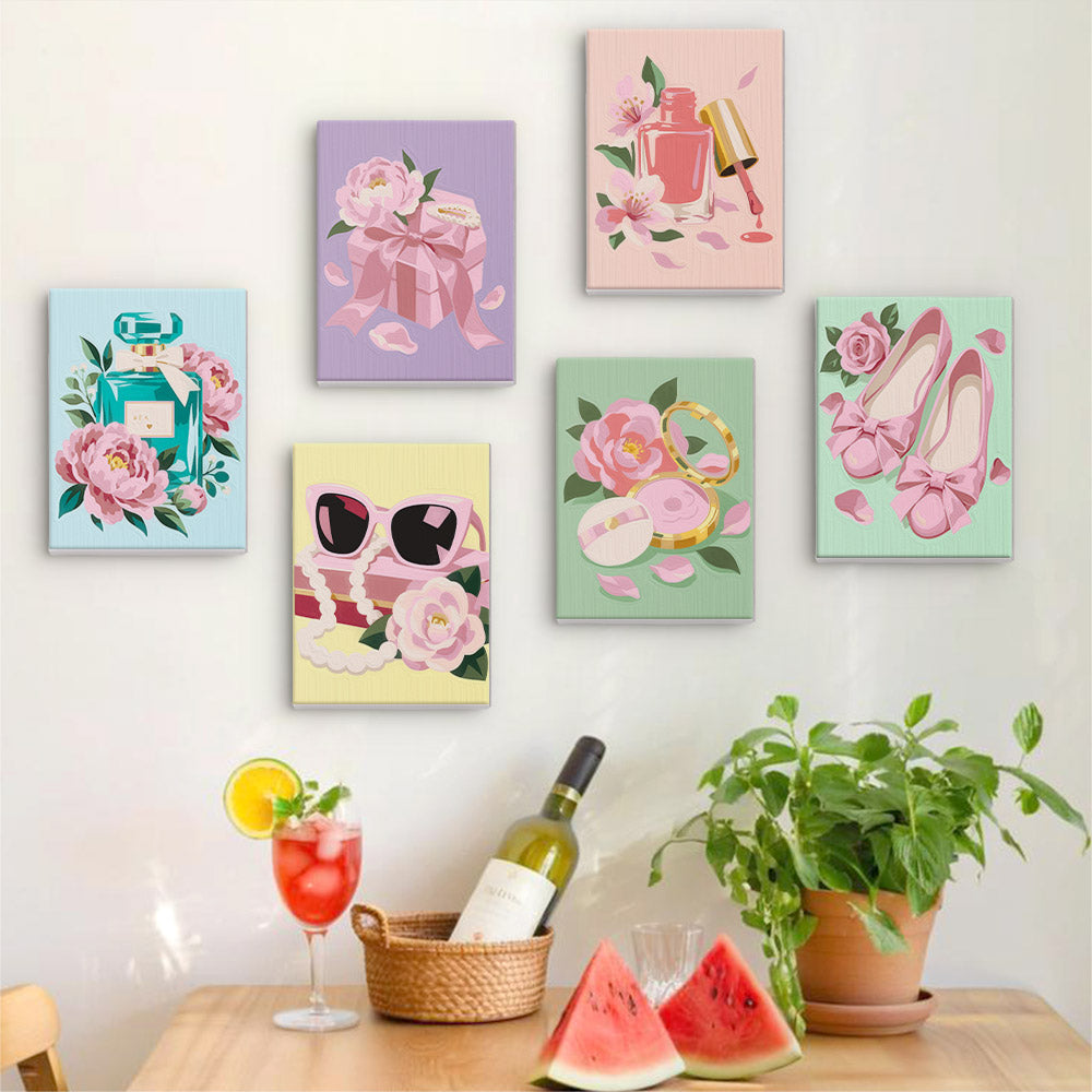 Six finished Pink Glam mini paintings hung on a wall above a table