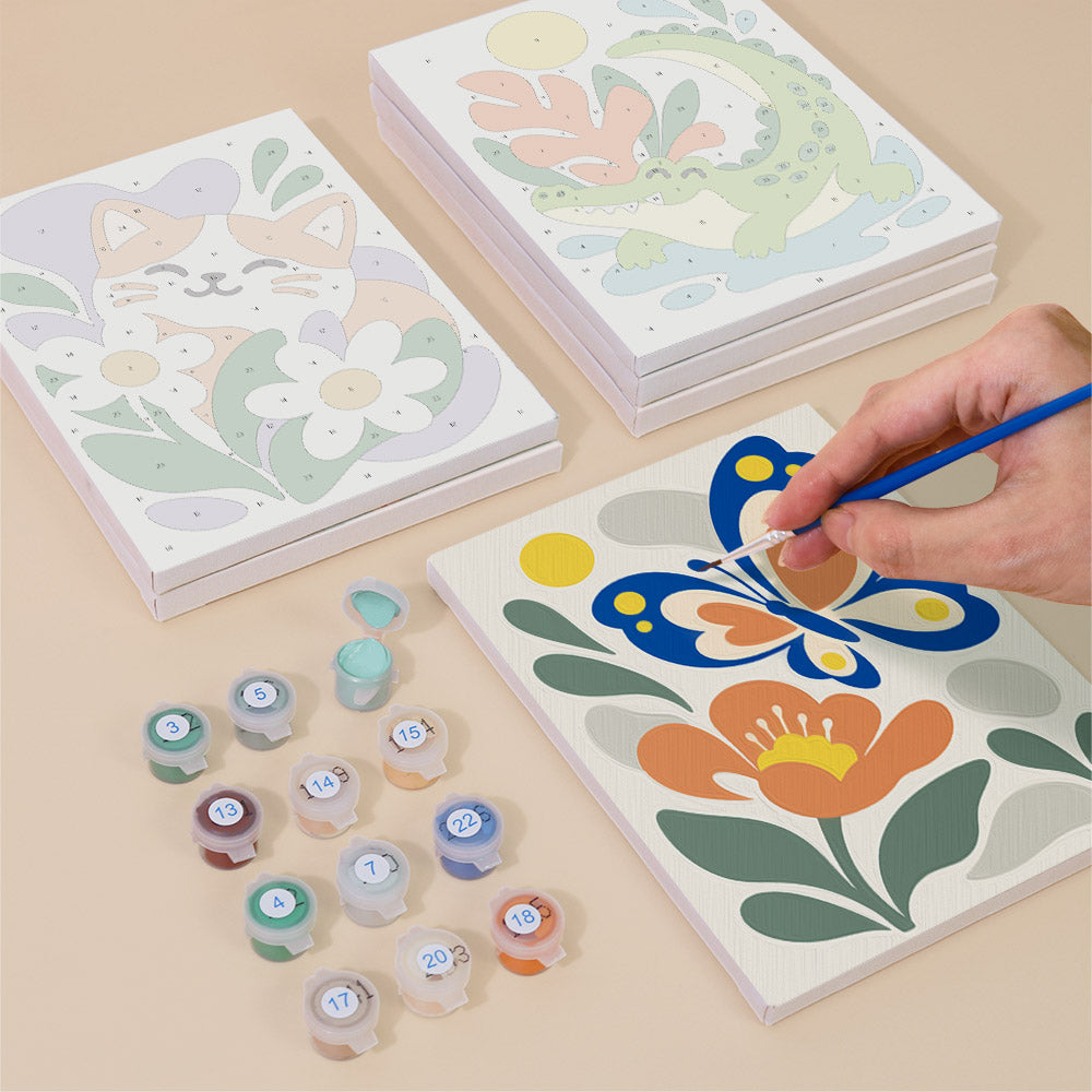 Painting one of the Playful Garden designs next to a stack of mini canvases