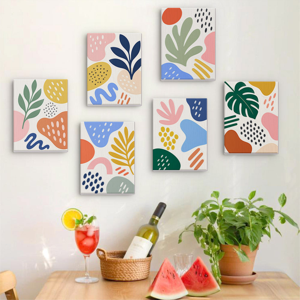 Six finished Playful Shapes mini paintings hung on a wall above a table