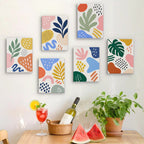 Six finished Playful Shapes mini paintings hung on a wall above a table