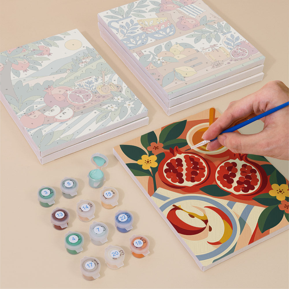 Painting one of the Pomegranate Kitchen designs next to a stack of mini canvases