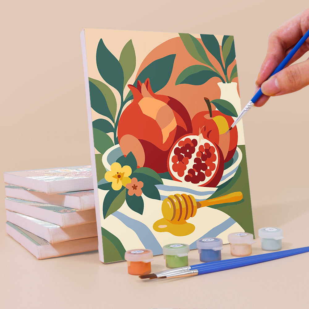 Painting a Pomegranate Kitchen mini canvas propped up beside numbered acrylic paints