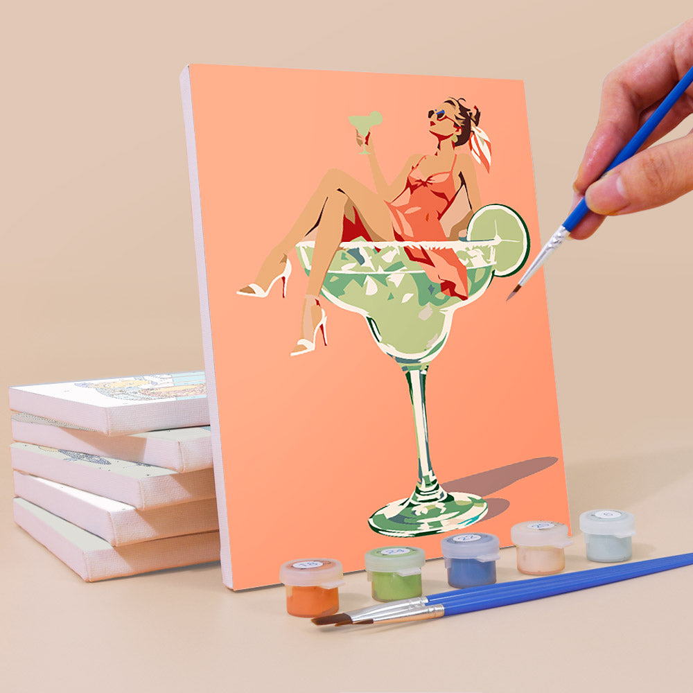 Painting a Poolside Cocktails mini canvas propped up beside numbered acrylic paints