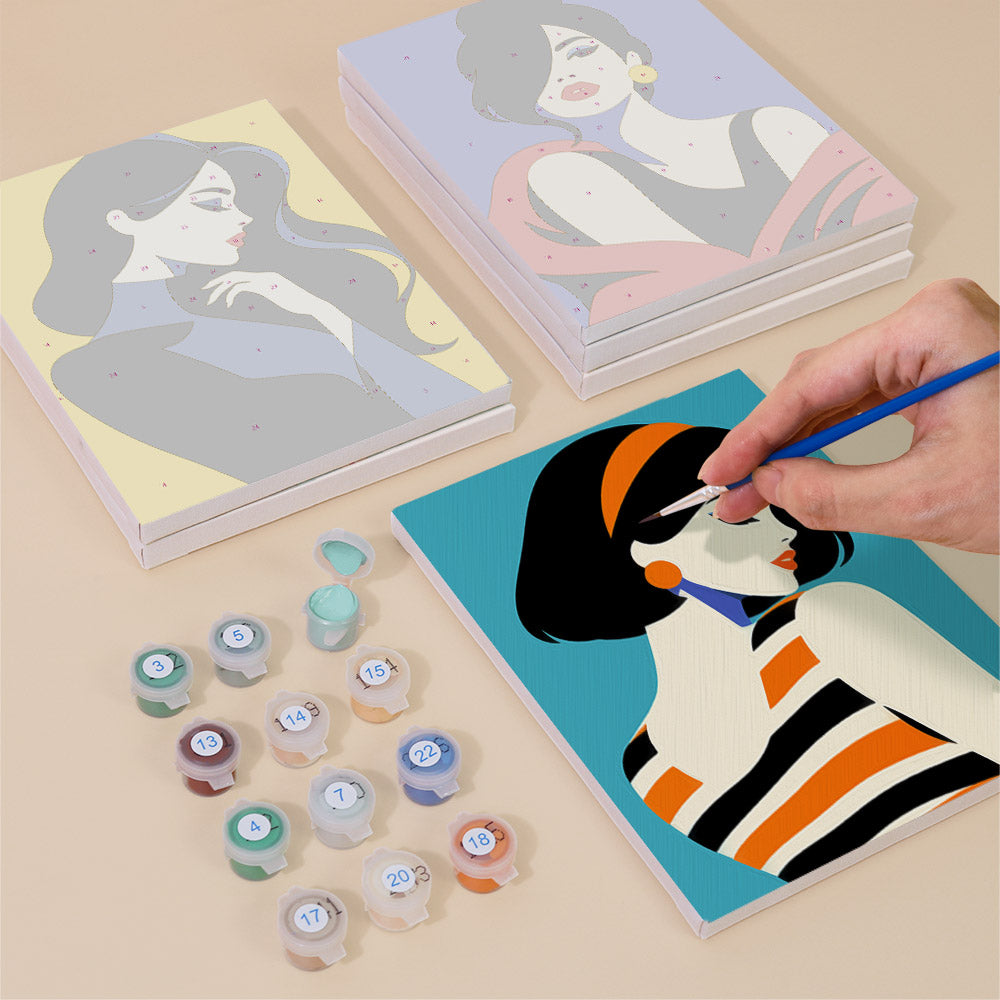 Painting one of the Pop Art Ladies designs next to a stack of mini canvases