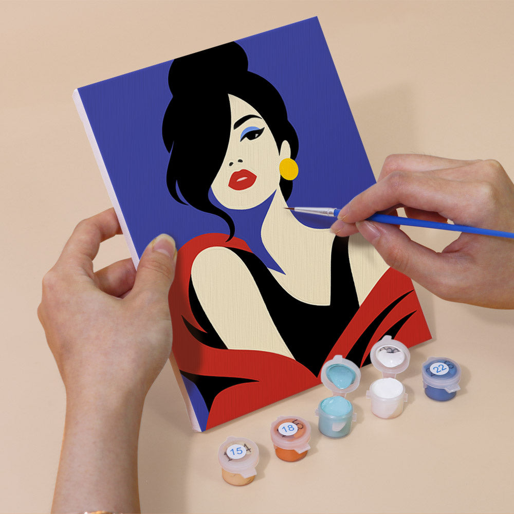Hand holding a Pop Art Ladies mini canvas while painting the details