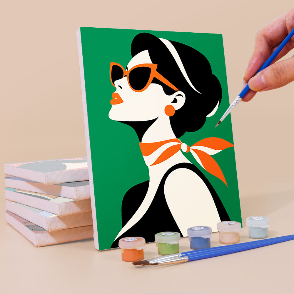 Painting a Pop Art Ladies mini canvas propped up beside numbered acrylic paints