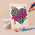 Painting a Pop Attitude mini canvas propped up beside numbered acrylic paints