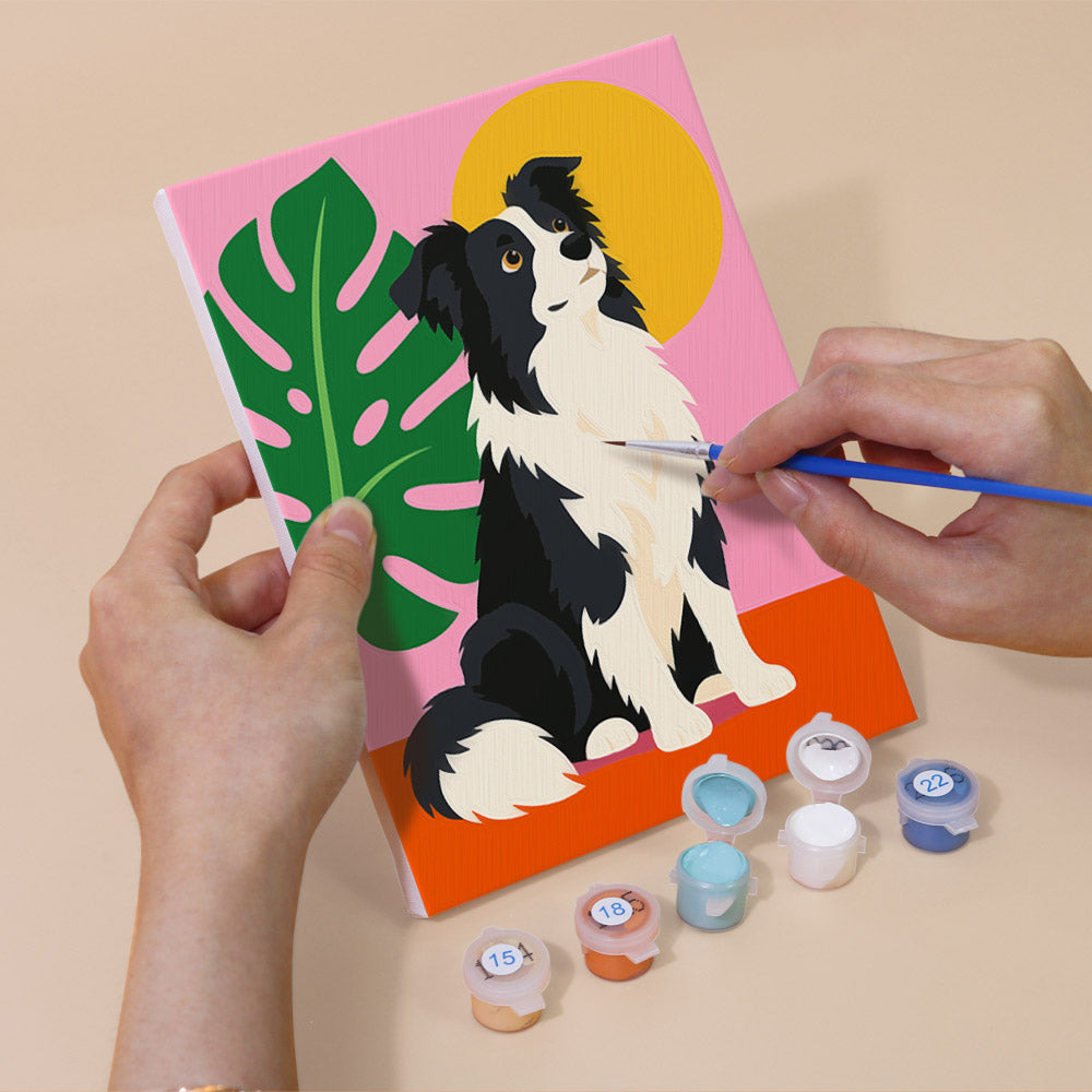 Hand holding a Pop Pups mini canvas while painting the details