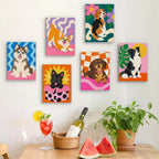Six finished Pop Pups mini paintings hung on a wall above a table