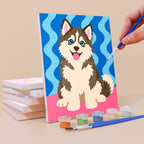Painting a Pop Pups mini canvas propped up beside numbered acrylic paints