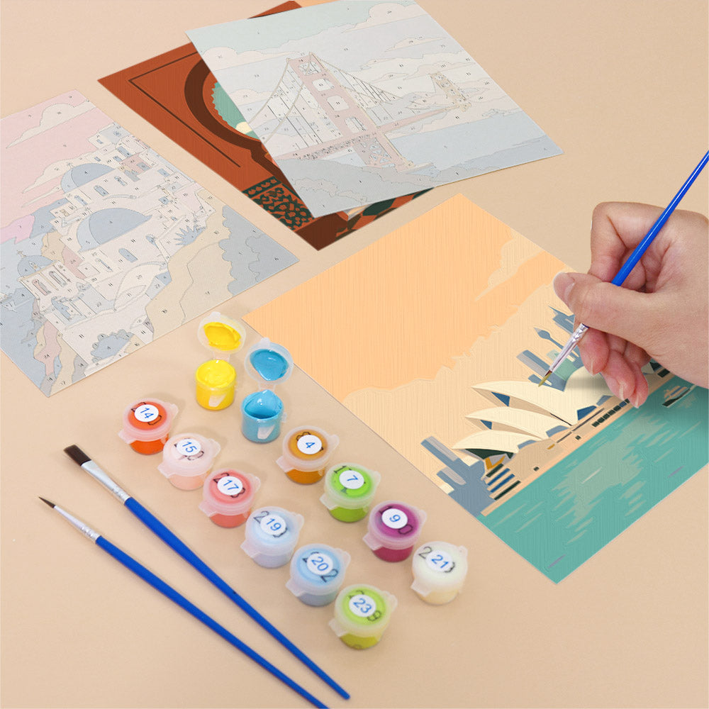 Filling in a Postcards from Afar mini canvas with numbered acrylic paints and a fine brush
