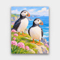 Puffins on the Cliff paint by numbers kit of two puffins on a grassy sea cliff with pink sea thrift and blue sea