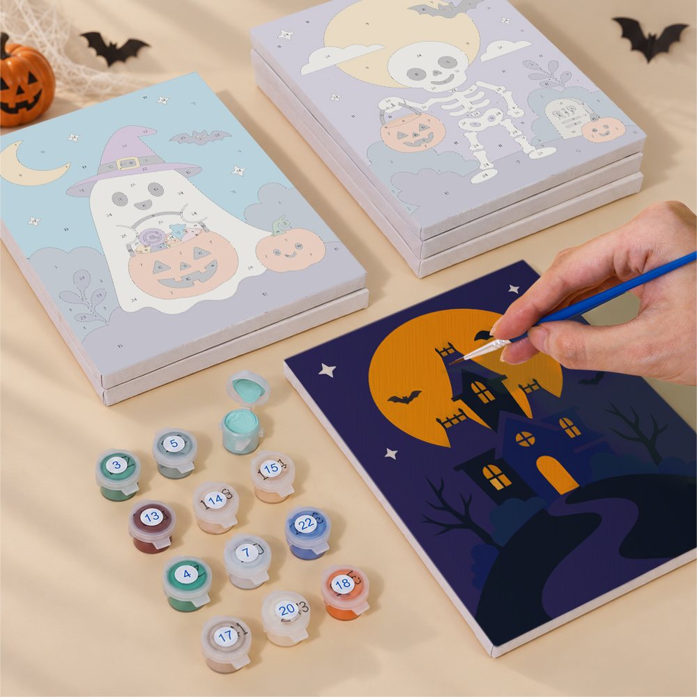 Painting one of the Purple Moon Spooks designs next to a stack of mini canvases