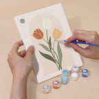 Hand holding a Quiet Botanicals mini canvas while painting the details