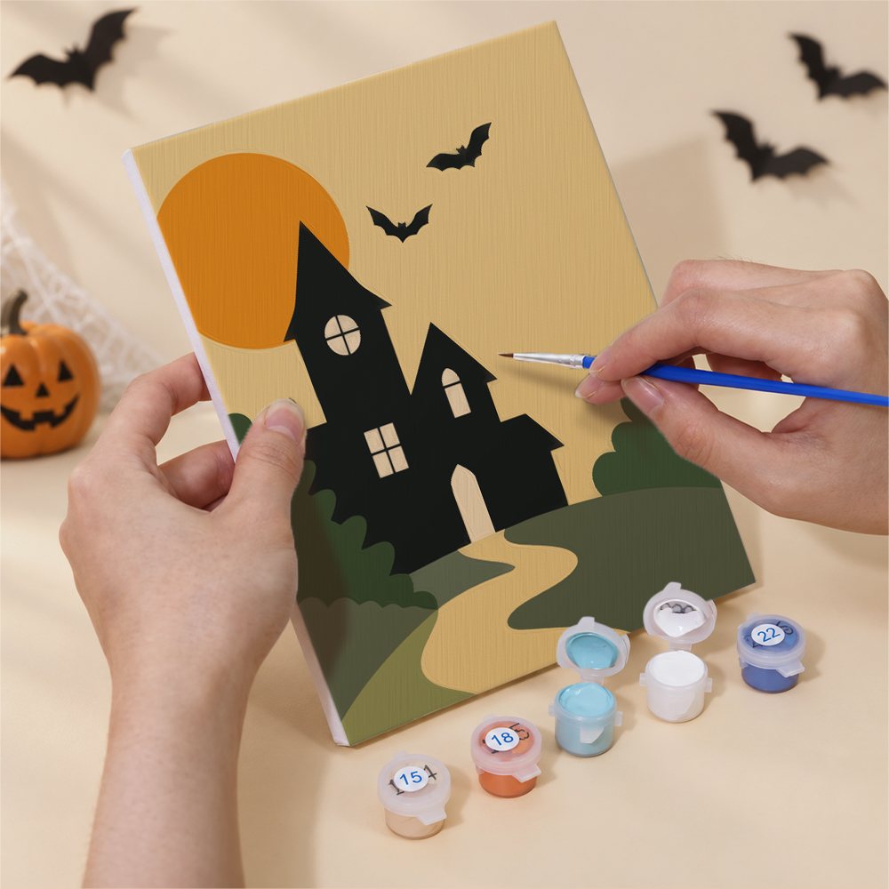 Hand holding a Quiet Hauntings mini canvas while painting the details