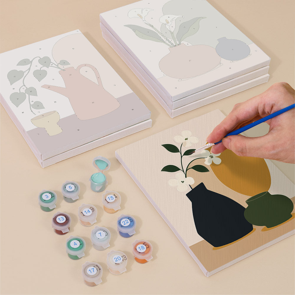 Painting one of the Quiet Vessels designs next to a stack of mini canvases